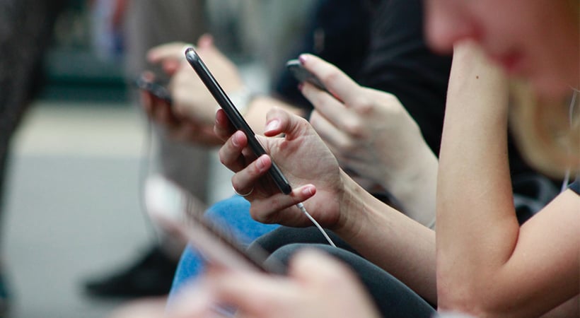 Several teenagers using mobile phones